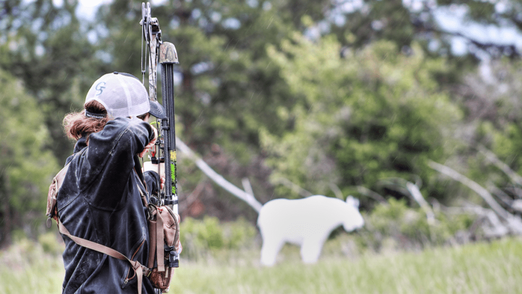 women shooting bow and arrow at 3D target